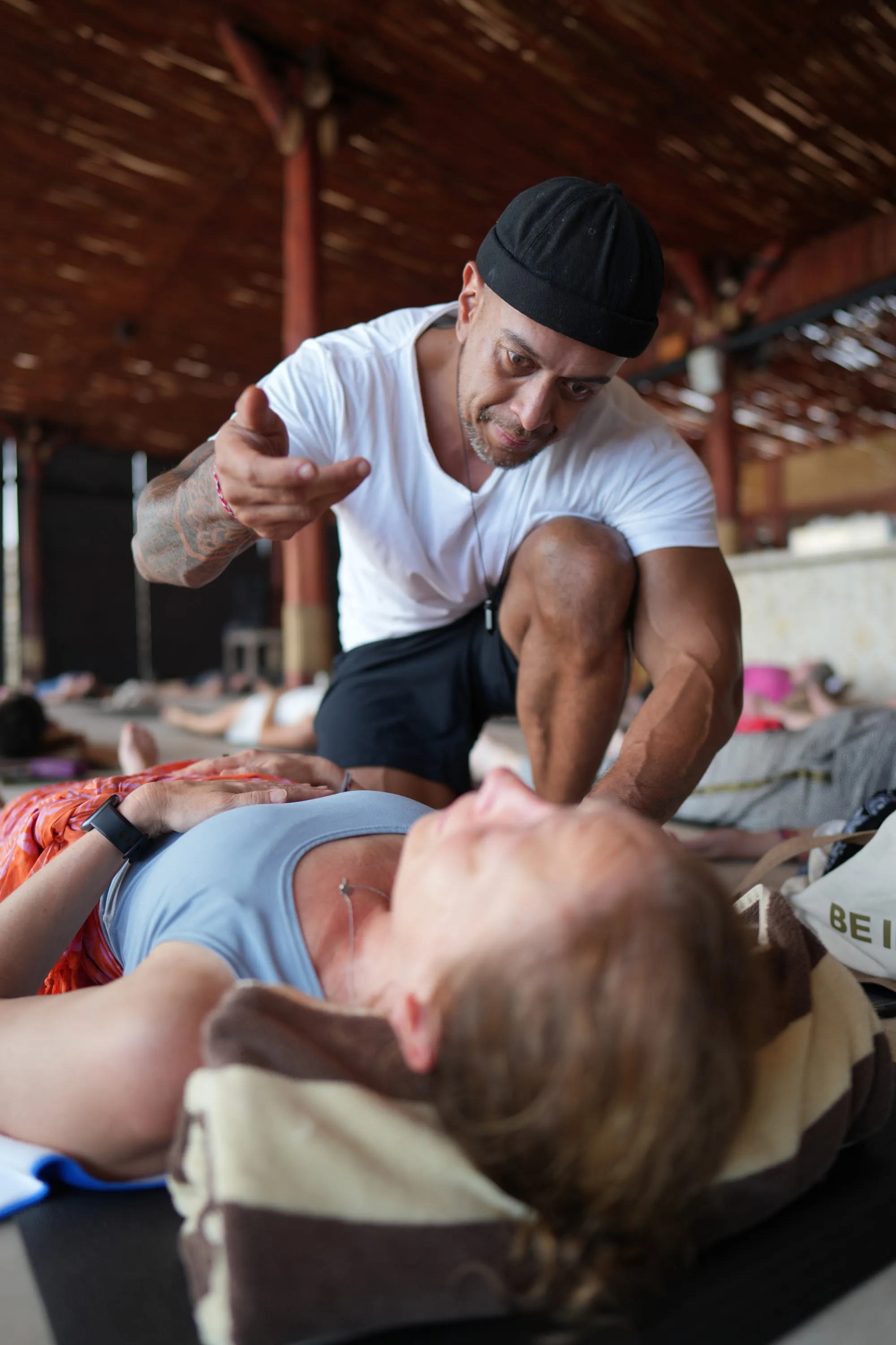 A participant lying with eyes closed while Andy rests his hands on her